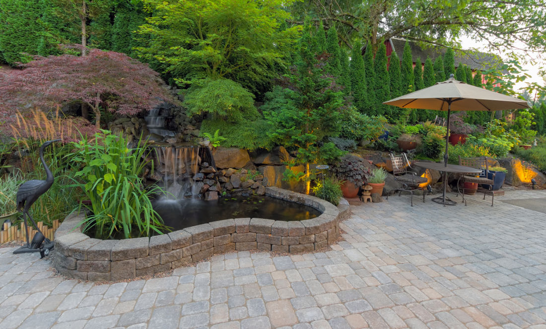 large paver patio with a pond table and umbrella